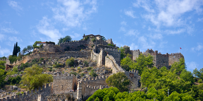 St. Hilarion Kalesi’nin surları ve dağın zirvesine kadar uzanan taş yapıları, yeşil doğa ile çevrili olarak görülüyor.